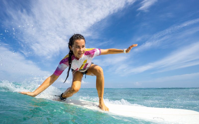 A photo of a woman catching a wave while surfing