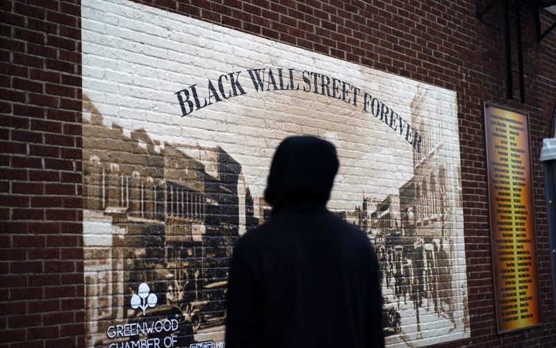 A man looks at a Black Wall Street mural in the historic Greenwood neighborhood of Tulsa, Oklahoma.