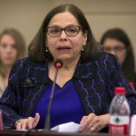 Judith Heumann, special advisor for International Disability Rights at the U.S. Department of State, sits at a table and speaks at the opening session of the China-U.S. Coordination Meeting on Disability in Beijing.