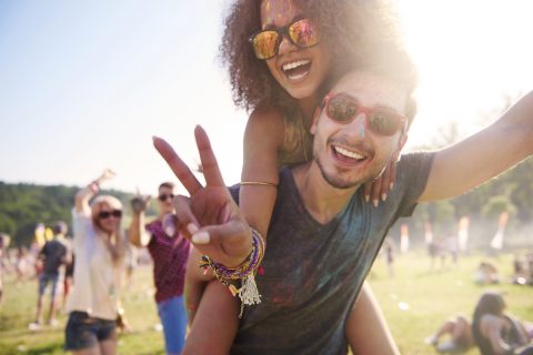 Two friends pose for a photo at a festival.