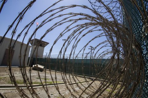 In this photo reviewed by U.S. military officials, the control tower is seen through the razor wire inside the Camp VI detention facility, Wednesday, April 17, 2019, in Guantanamo Bay Naval Base, Cuba.