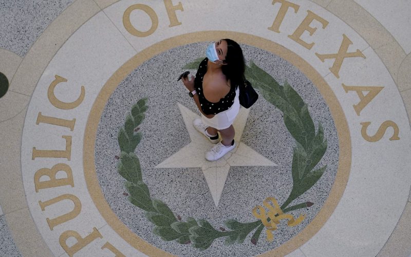 A visitor wears a protective mask during a visit to the Texas Capitol.