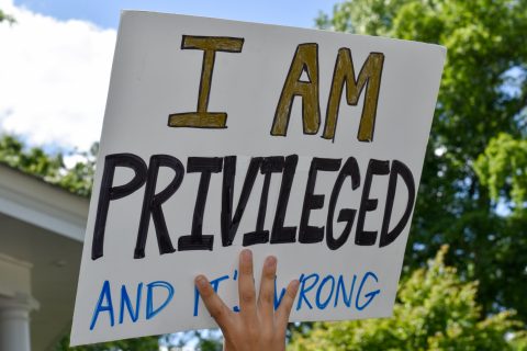 A High School Student Holding Up A Sign That Says "I Am Privileged And It's Wrong."