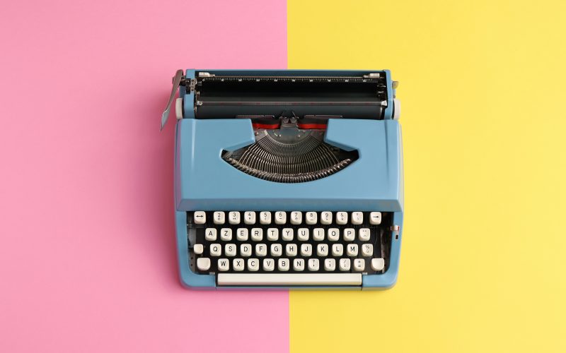 A typewriter on a colorful background.