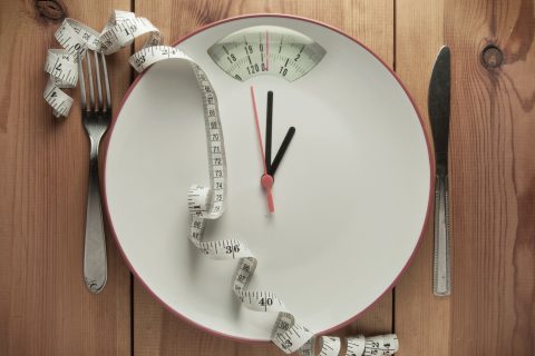 A plate made to look like a scale, with a tape measure draped over it.