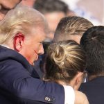 Donald Trump leaning on secret service members after an attempted assassination