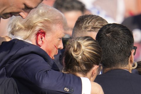 Donald Trump leaning on secret service members after an attempted assassination