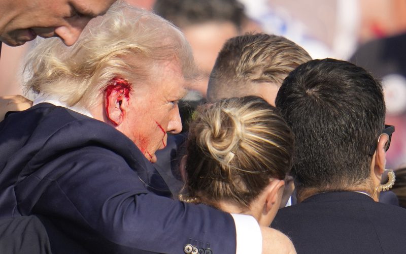 Donald Trump leaning on secret service members after an attempted assassination